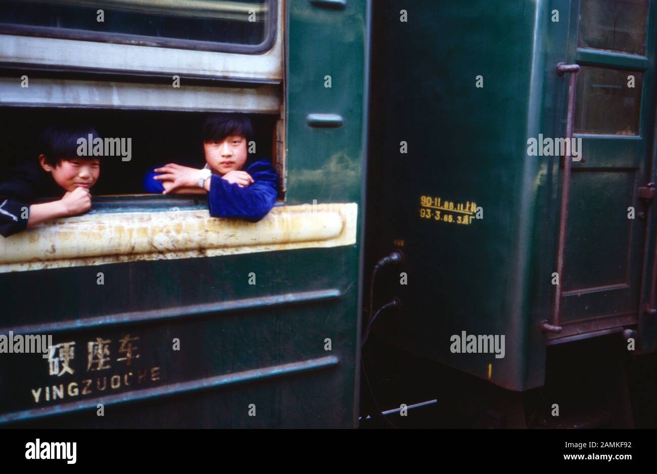 Zwei chinesische Kinder schauen aus dem Fenster eines Zuges, China 1980er Jahre. Two Chinese children looking out of the window of a train, China 1980s. Stock Photo