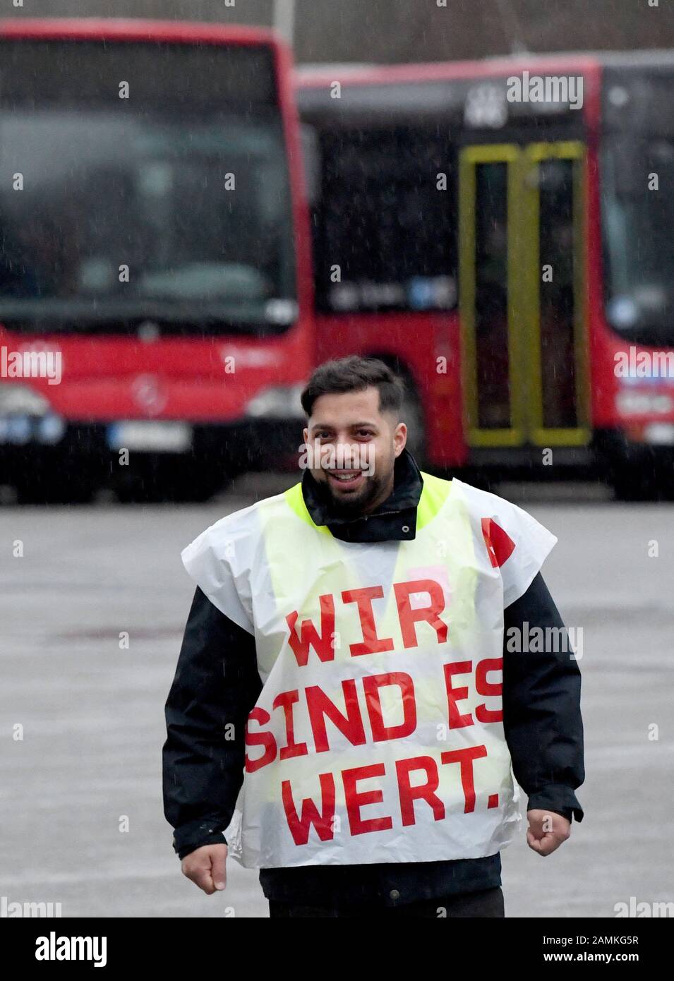 14 January 2020, Schleswig-Holstein, Kiel: A striking bus driver stands at the depot of the Kieler Verkehrsgesellschaft. The trade union Verdi had called for all-day warning strikes in the north in the wage dispute. Verdi Nord demands an increase in wages and salaries by 2.06 euros per hour from 01.01.2020 for around 1500 bus drivers. Photo: Carsten Rehder/dpa Stock Photo