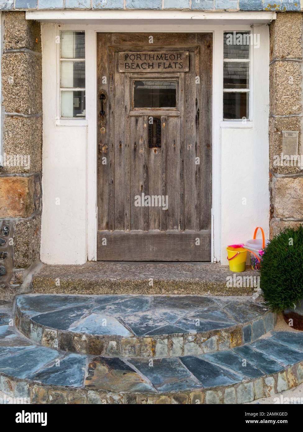 Old bare oak wooden front door and slate steps at entrance to Porthmeor
