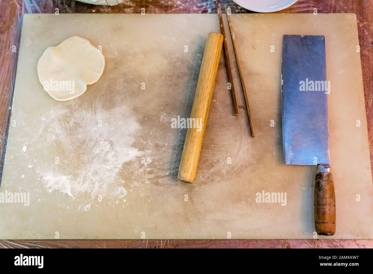 Chopping board, knife, rolling pin and chopsticks which will be used for the making of
