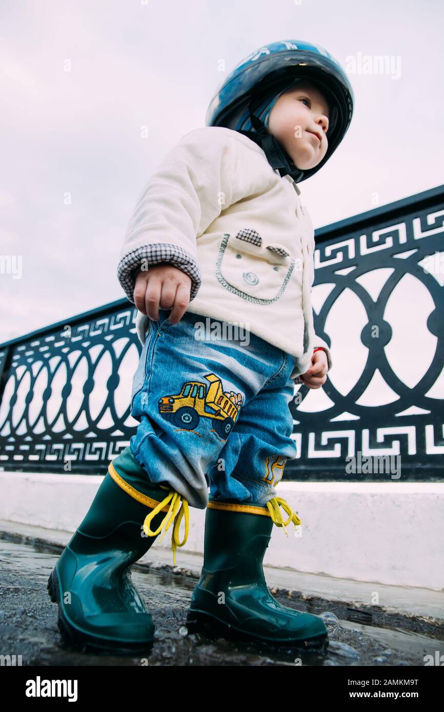 child walks through the puddles in rubber boots Stock Photo - Alamy