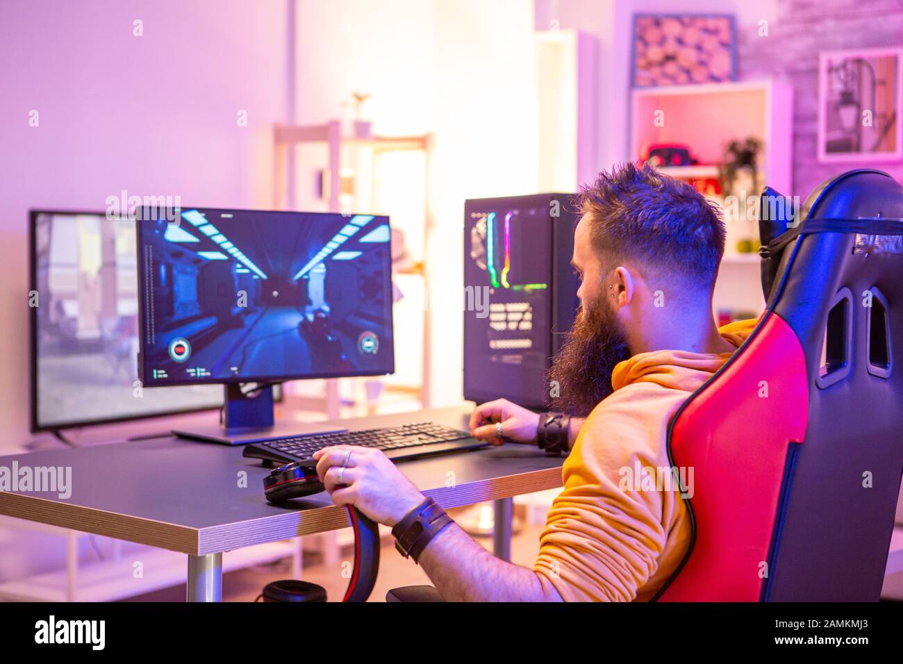 Bearded man playing online video games on his pc and talking with