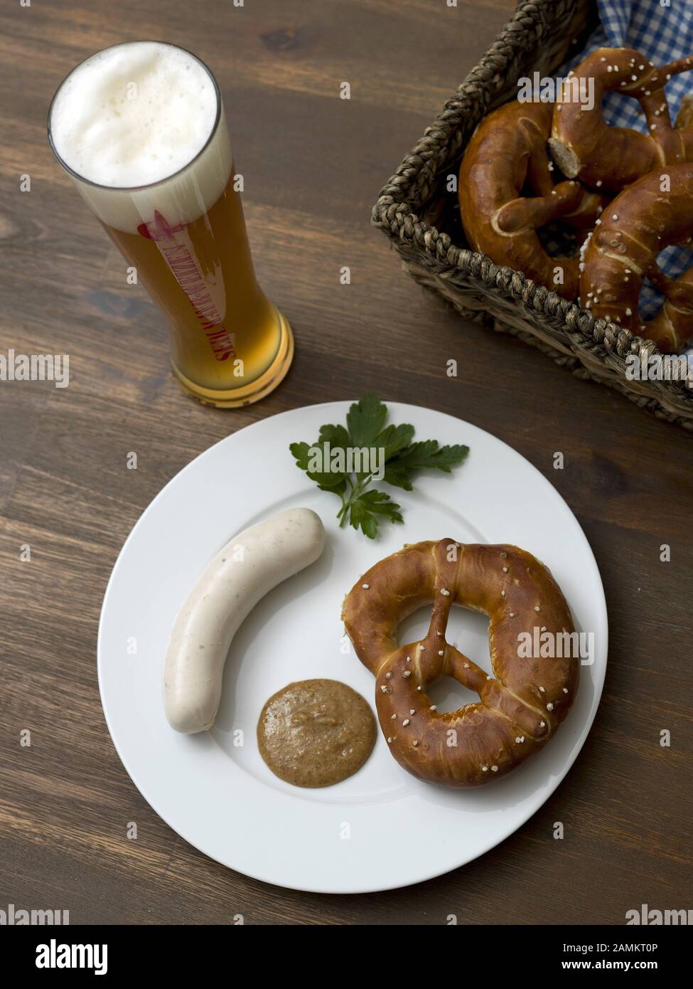 Bavarian snack with white sausage, parsley, pretzel, sweet mustard and a wheat beer. [automated translation] Stock Photo