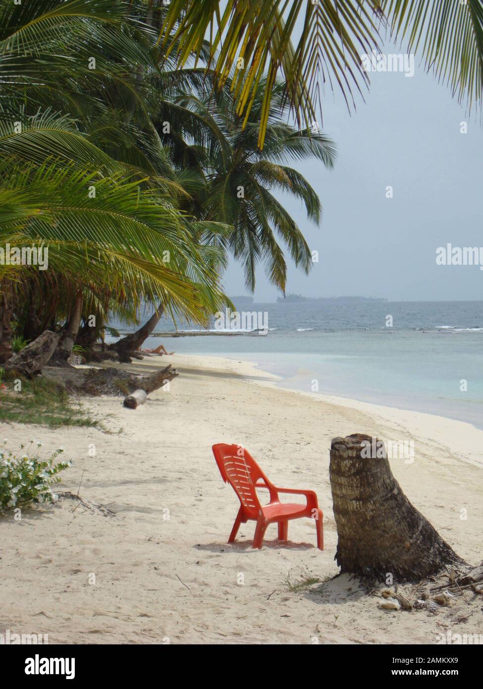 lonely red plastic chair on the sandy beach of the San Blas Islands