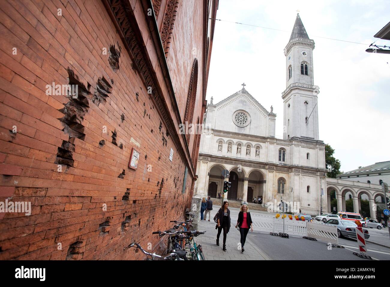 On the wall of the brick building of the Munich Ludwig-Maximilians-University (LMU) at the corner of Ludwigstraße / Schellingstraße are bullet holes from the Second World War. In the background the Ludwigskirche. [automated translation] Stock Photo