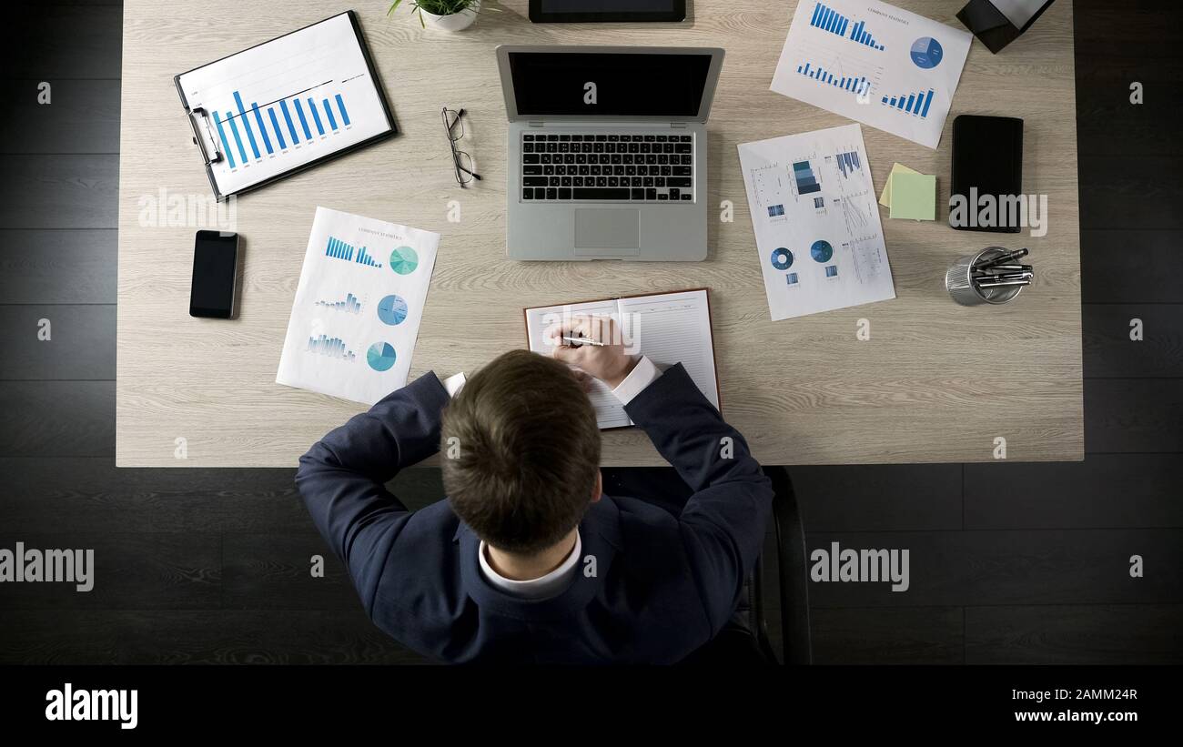 Responsible businessman writing in notebook, making to-do list, time management Stock Photo