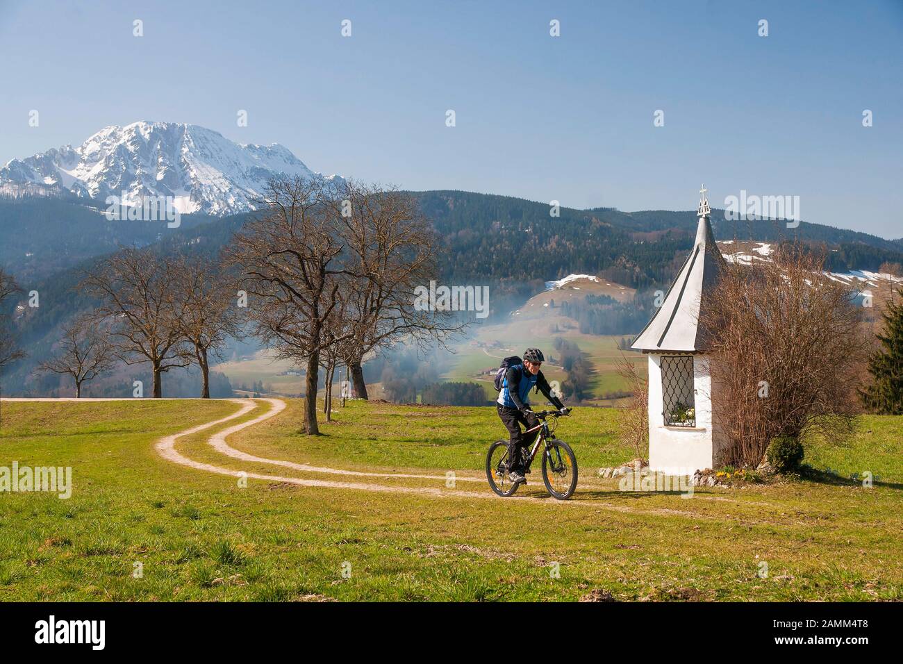 Mountain bikers in early spring on tour in the village of Anger at the Felber-Bildstock with the Zwiesel in the background [automated translation] Stock Photo