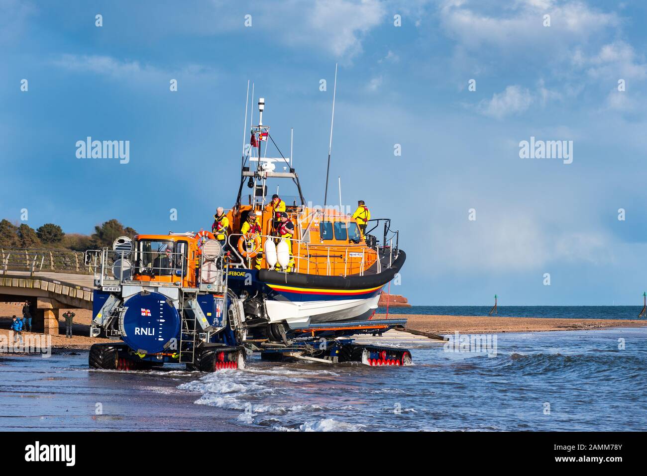 EXMOUTH, DEVON, UK - 3APR2019: RNLB R & J Welburn, a Shannon Class lifeboat, towed by tractor along the beach to a launch position during a regular ex Stock Photo