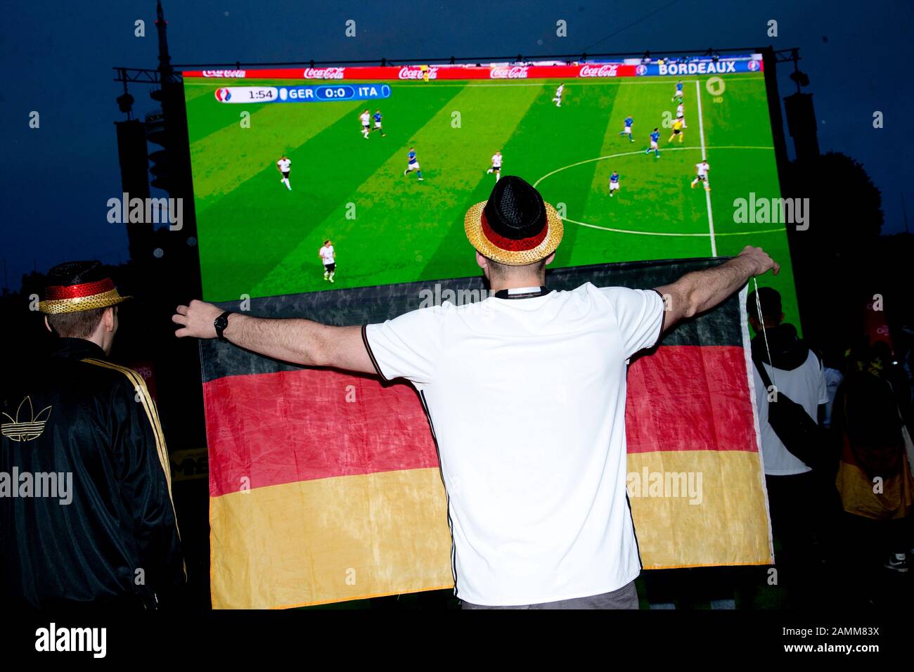 Football fans at the Public Viewing in the Olympic Stadium on the occasion of the quarter final match between Germany and Italy during the European Football Championship 2016. [automated translation] Stock Photo