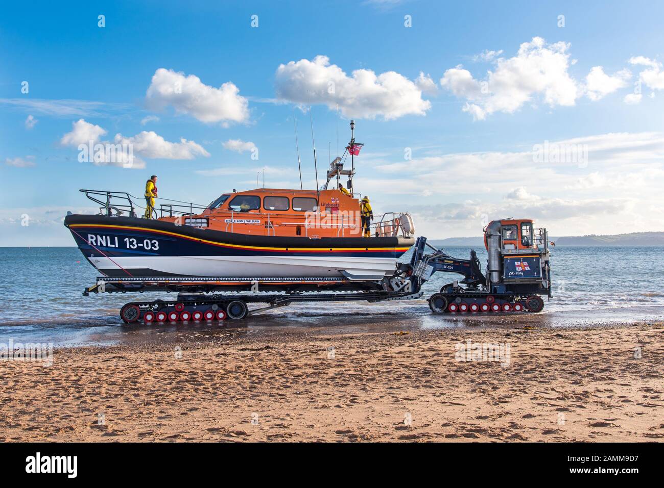 EXMOUTH, DEVON, UK - 3APR2019: RNLB R & J Welburn, a Shannon Class lifeboat, towed by tractor along the beach to a launch position during a regular ex Stock Photo