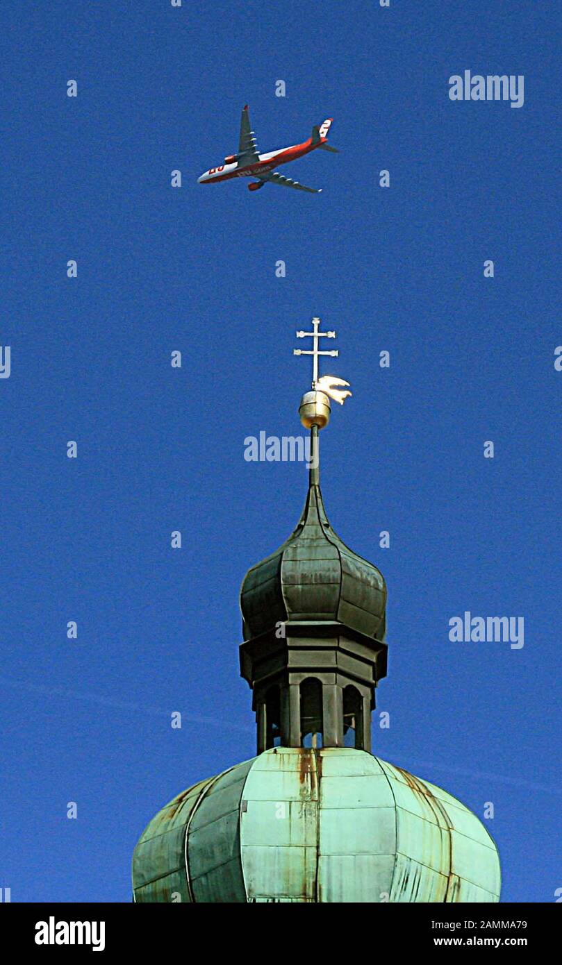A commercial airplane of the tour operator LTU flies over the tower of the church St. Jakob in Dachau. [automated translation] Stock Photo