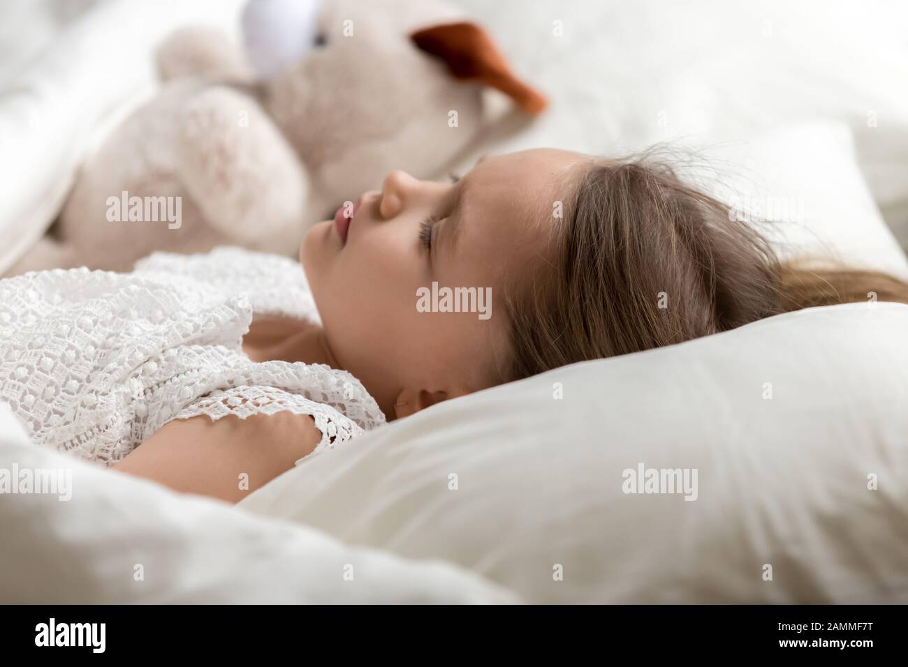 Cute little girl, peaceful child sleeping in bed with toy Stock Photo