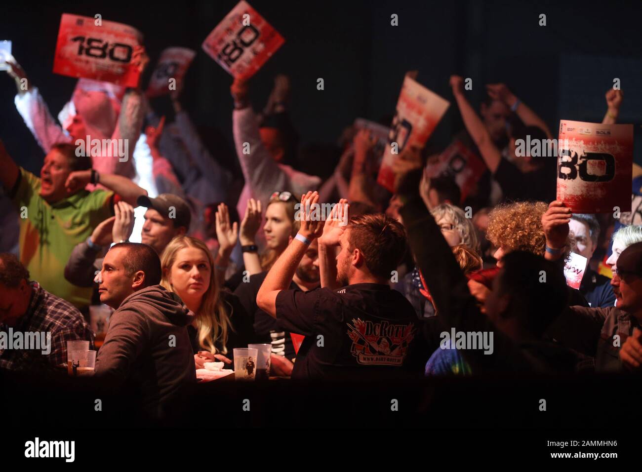 Fans at the German Darts Grand Prix at the Zenith in Munich. Cardboard signs with the magic score of 180 are held up. [automated translation] Stock Photo