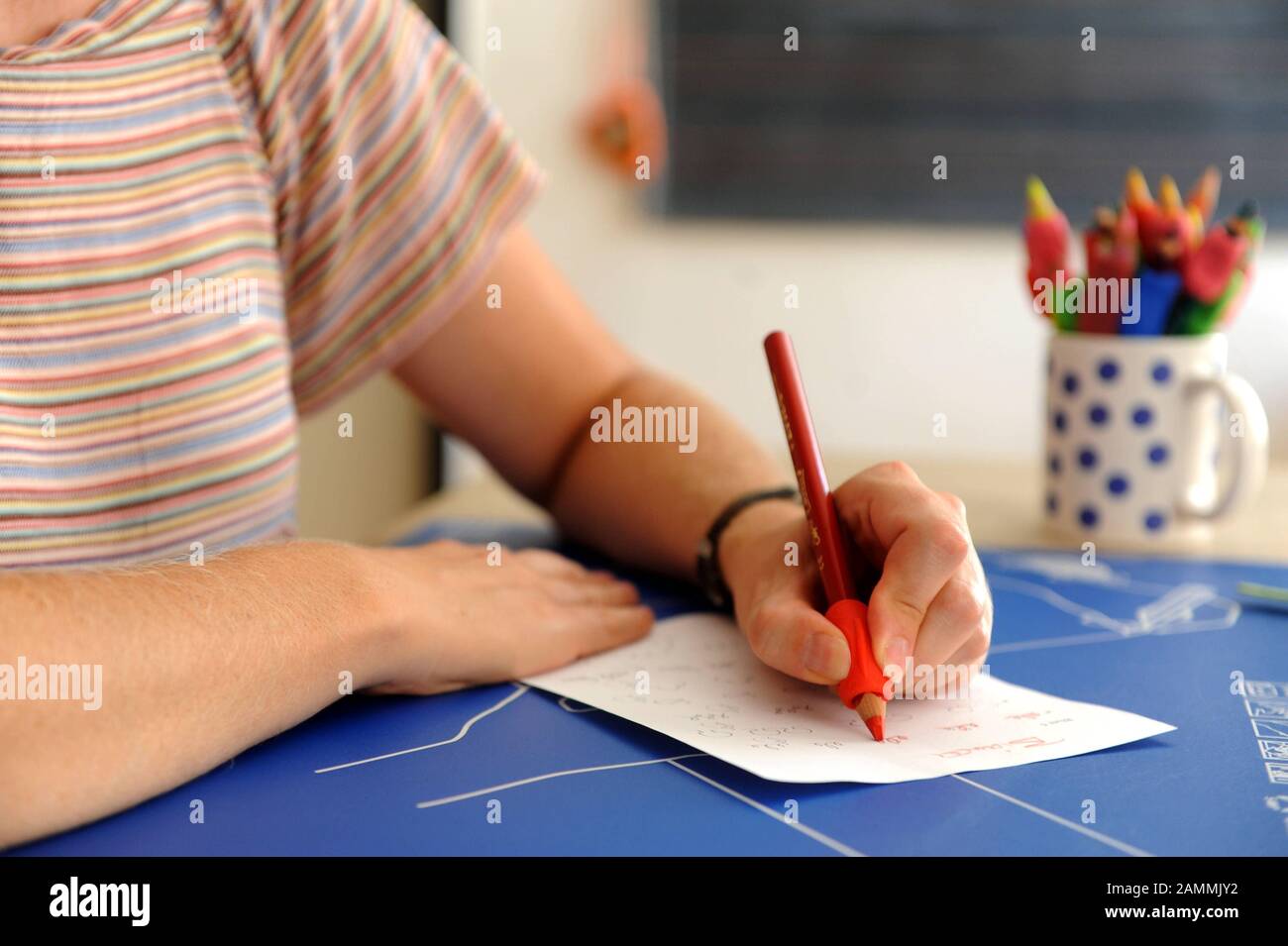 Barbara Sattler, head of the First German Counselling and Information Centre for Left-Handers and Retrained Left-Handers in Munich, has developed a rubber cuff for pens that facilitates the correct writing posture. In the picture a retrained left-handed woman learns to write again with her dominant hand. [automated translation] Stock Photo