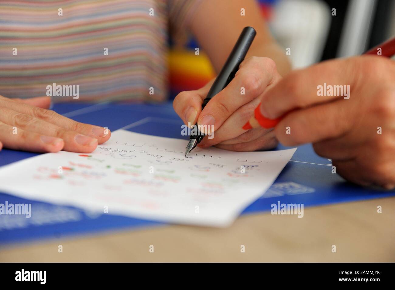 Barbara Sattler, head of the First German Counselling and Information Centre for Left-Handers and Retrained Left-Handers in Munich, has developed a rubber cuff for pens that facilitates the correct writing posture. In the picture a retrained left-handed woman learns to write again with her dominant hand. [automated translation] Stock Photo