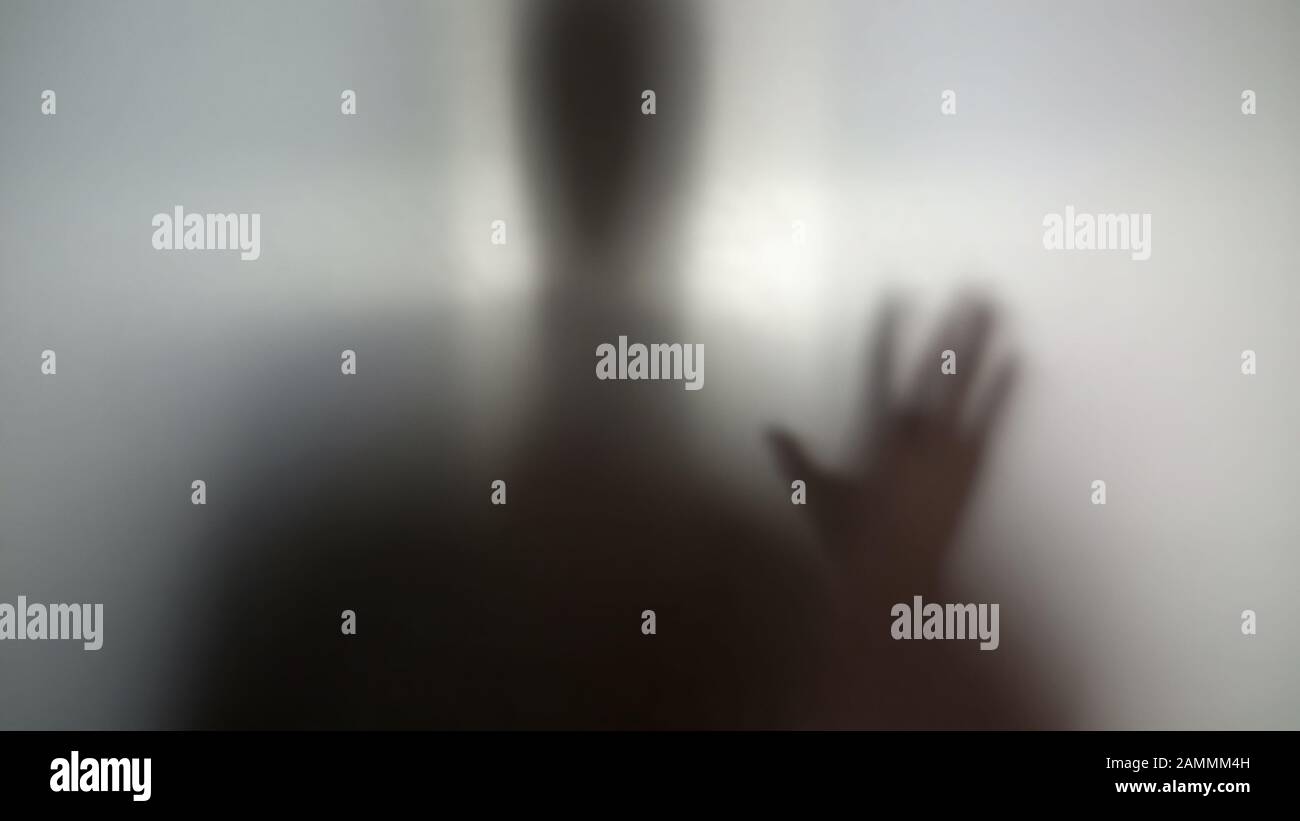 Man needs help, drug addiction, silhouette behind wall asking for help anonymity Stock Photo