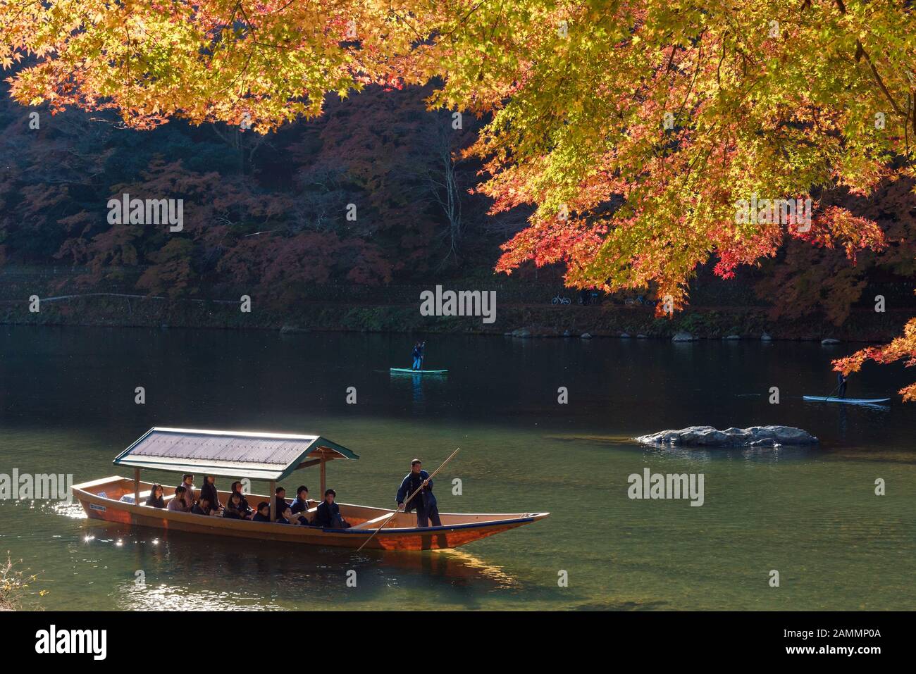 KYOTO,JAPAN-NOV26:Unidentified tourists on wooden boat enjoy autumn colors along Hozu gawa river at Arashiyama in Kyoto on November 26,2106.Arashiyama Stock Photo