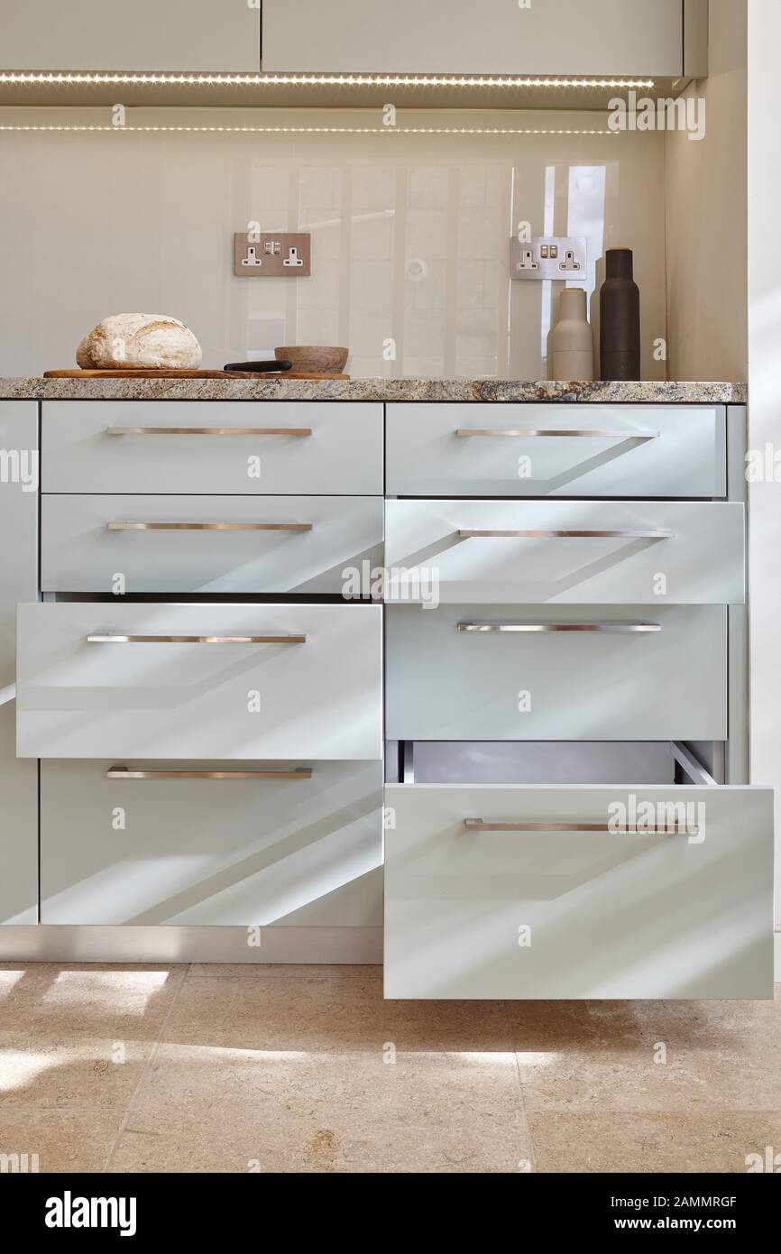 Pull out storage drawer with white dishes in modern kitchen Stock Photo -  Alamy