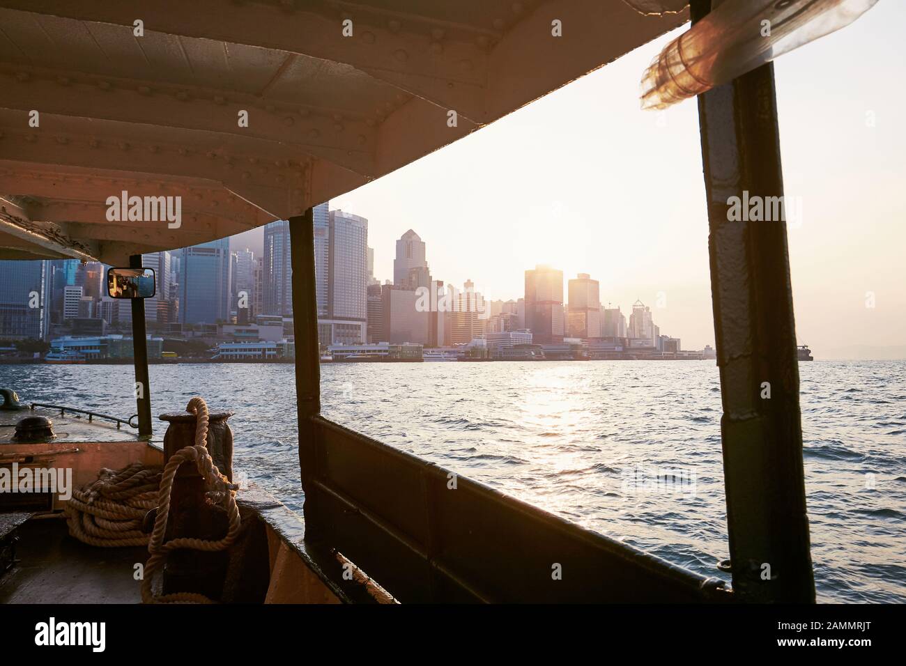 Cityscape with skyscrapers in Hong Kong. View from ferry on modern city at beautiful sunset. Stock Photo