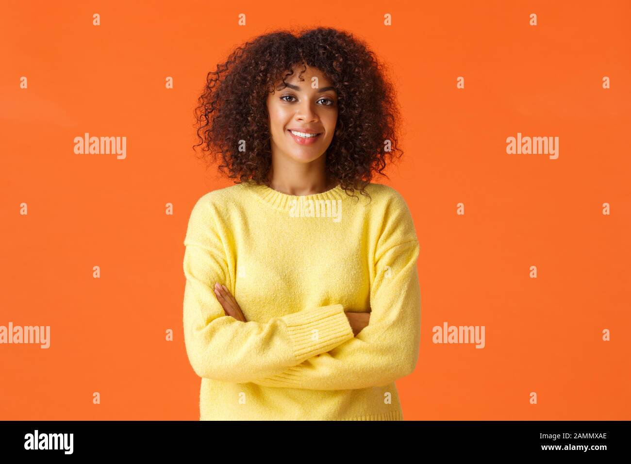 Professionalism, business and people concept. Pretty confident and creative african-american female coworker with curly hair, cross hands over chest Stock Photo