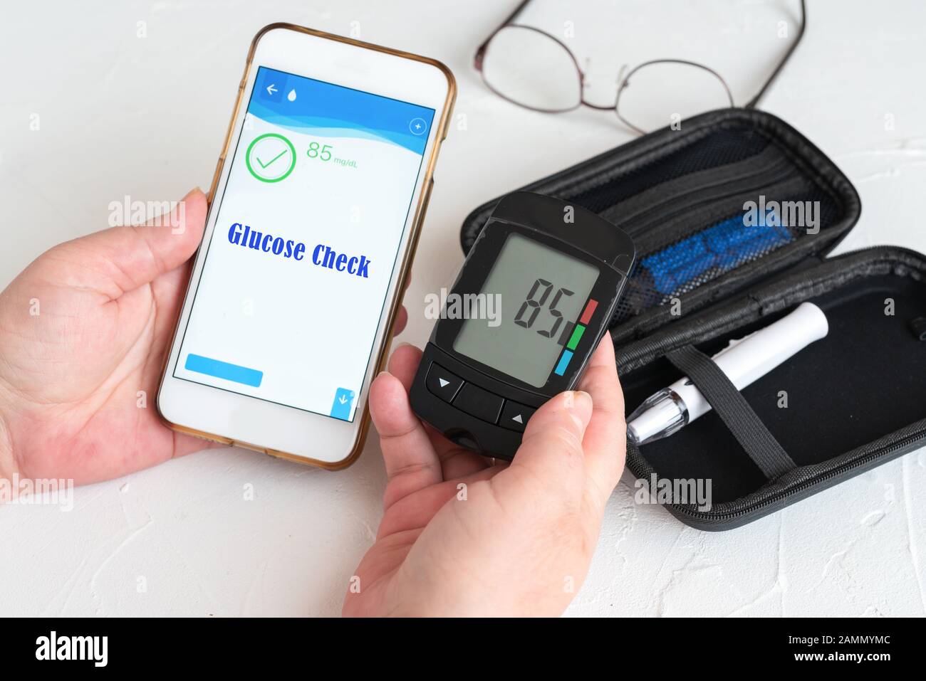 Measuring glucose levels and using smart phone. Healthcare and medical concept Stock Photo