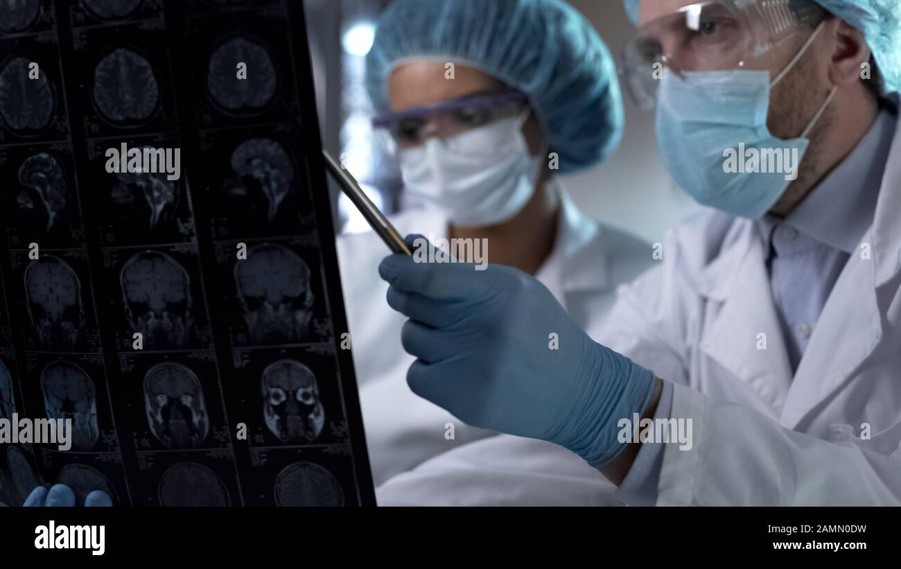 Neurosurgeon showing human MRI scan and giving explanation to medical intern Stock Photo Alamy