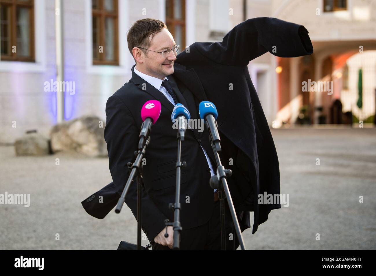 Seeon, Germany. 14th Jan, 2020. Hans Reichhart (CSU), State Minister of Housing, Construction and Transportation in Bavaria, throws his jacket over his head after his press statement at the closed meeting of the CSU state parliamentary group in Seeon Monastery. Bavarian Transport Minister Reichhart wants to resign from his cabinet post on 1st February and concentrate on the upcoming local elections in his Swabian home district of Günzburg. Credit: Matthias Balk/dpa/Alamy Live News Stock Photo