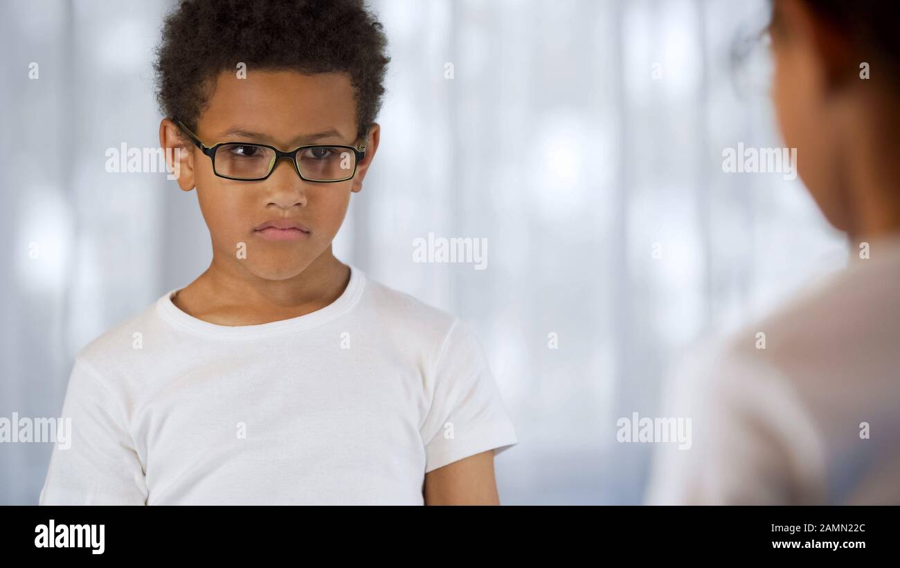 Upset child in eyeglasses looking mirror reflection, blurry vision, insecurities Stock Photo