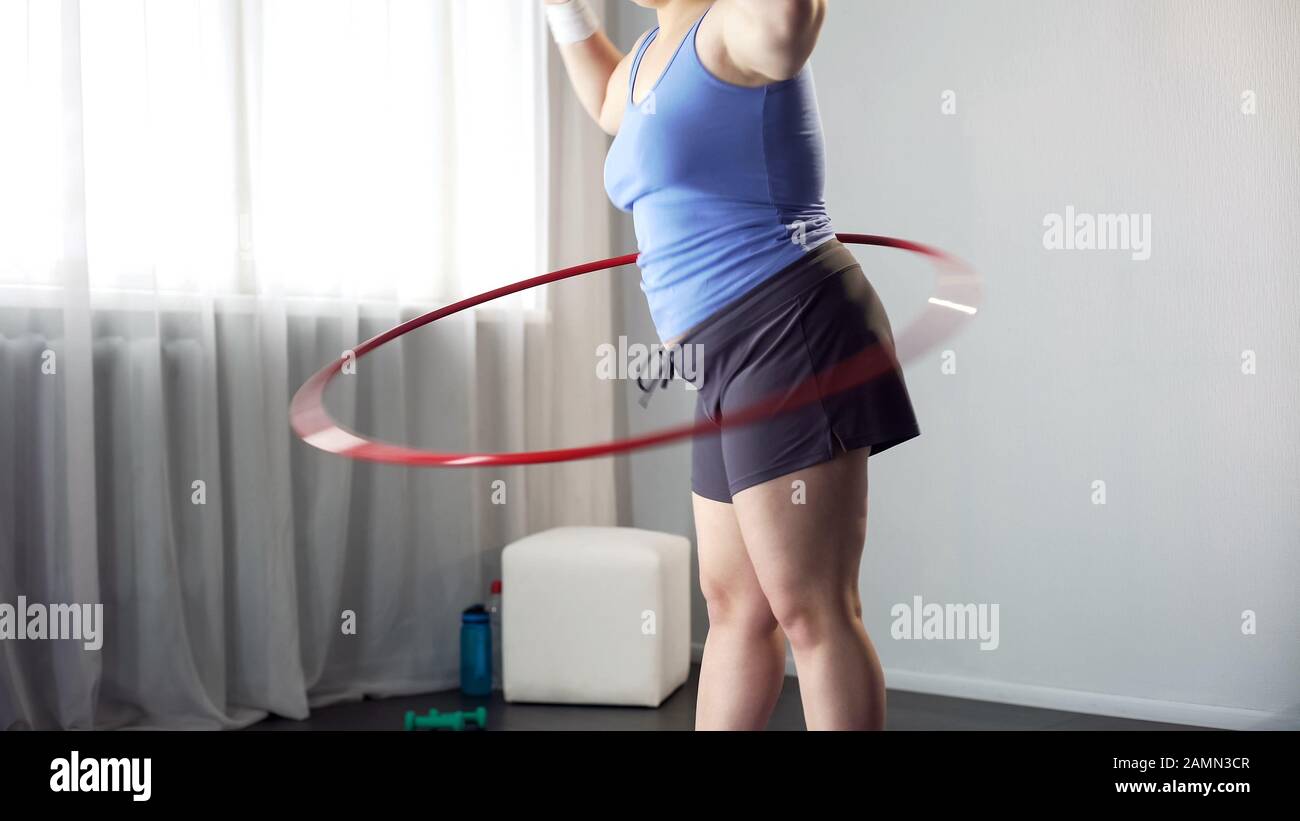 Overweight female twirling hula hoop, exercise for weight loss