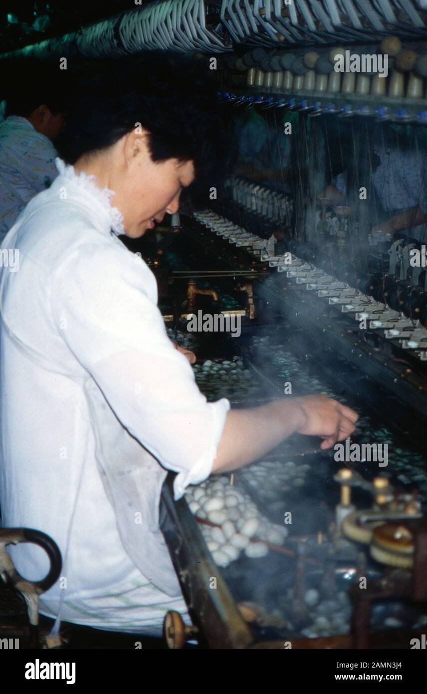 Arbeiter an einer Maschine in einer Seidenspinnerei in China, 1980er Jahre. Worker on a machine at a silk mill in China, 1980s. Stock Photo