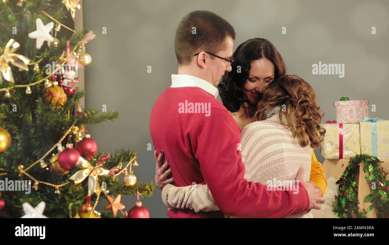 Friendly family hugging, congratulating each other on holidays, idyll at home Stock Photo