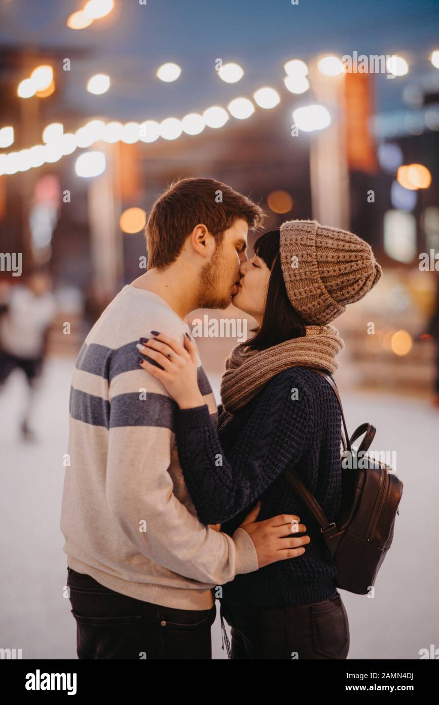 Young couple stands and kisses on the background of evening city lights  Stock Photo - Alamy