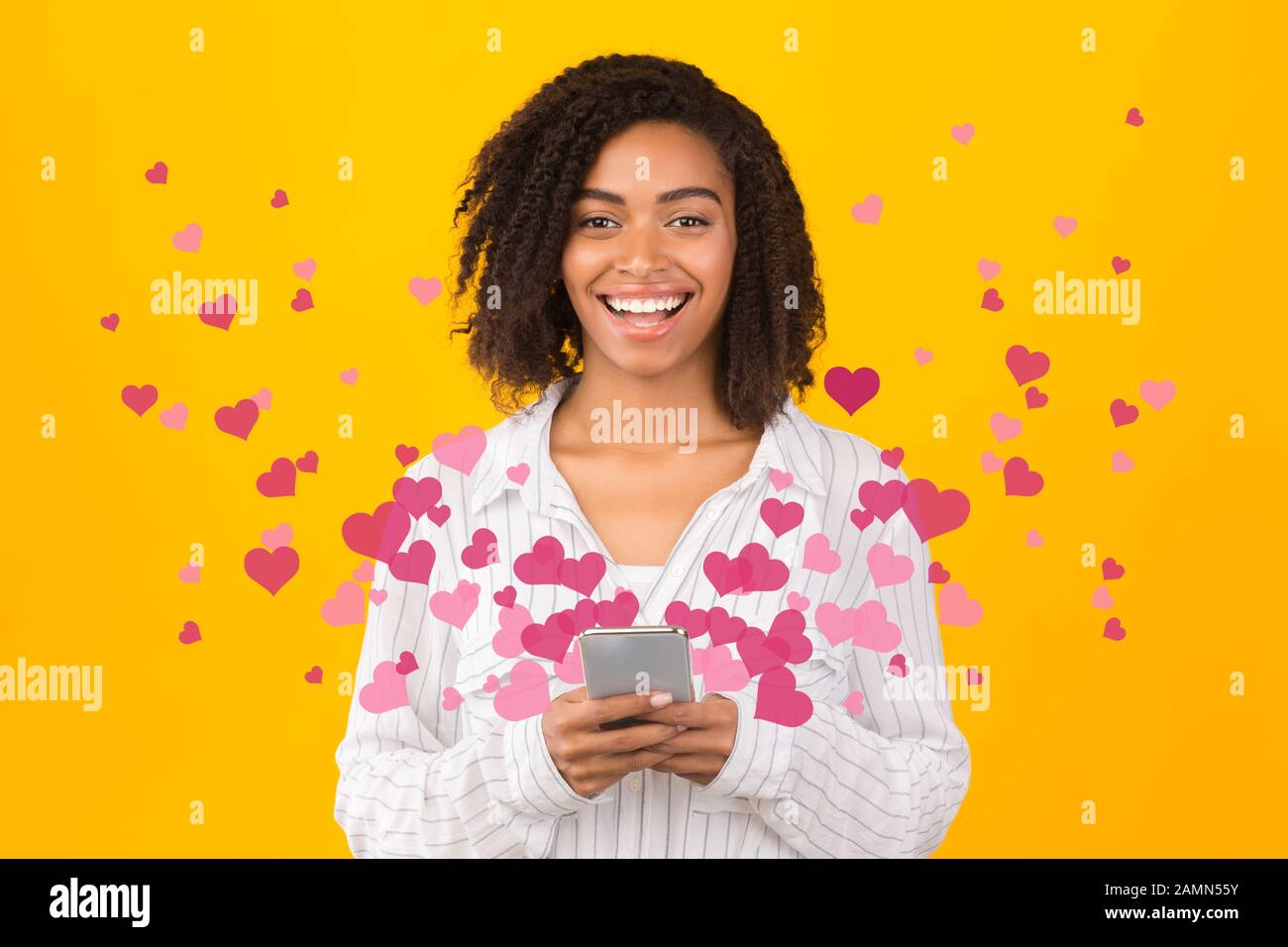 Happy afro girl excited about love text messages Stock Photo