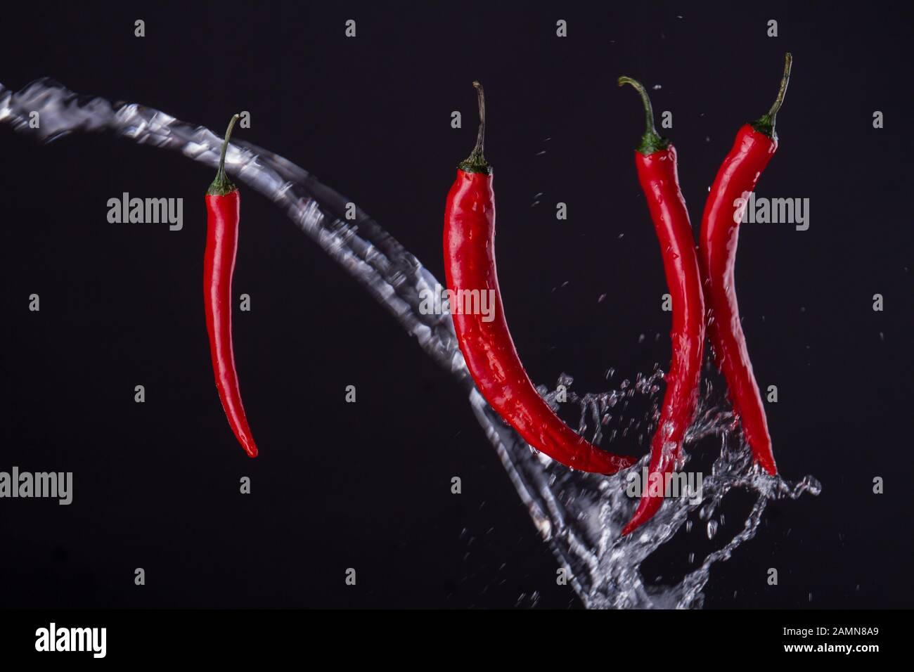 Cayenne peppers crossed with the stream of water Stock Photo Alamy
