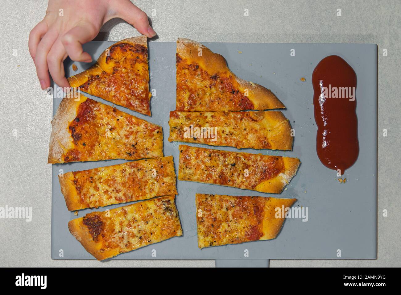 Hand taking a slice of pizza Stock Photo
