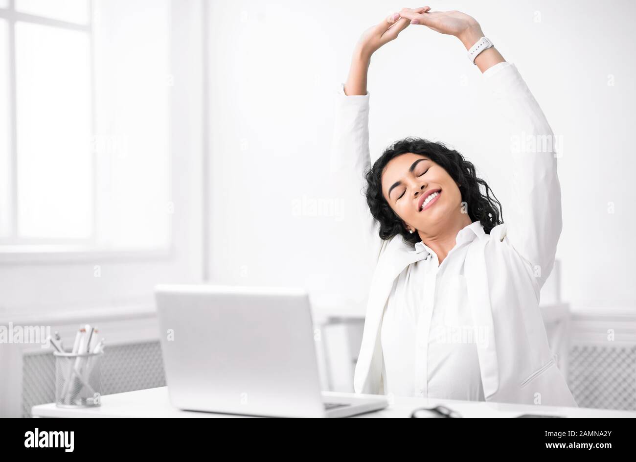 Mexican manager stretching hands at work place Stock Photo