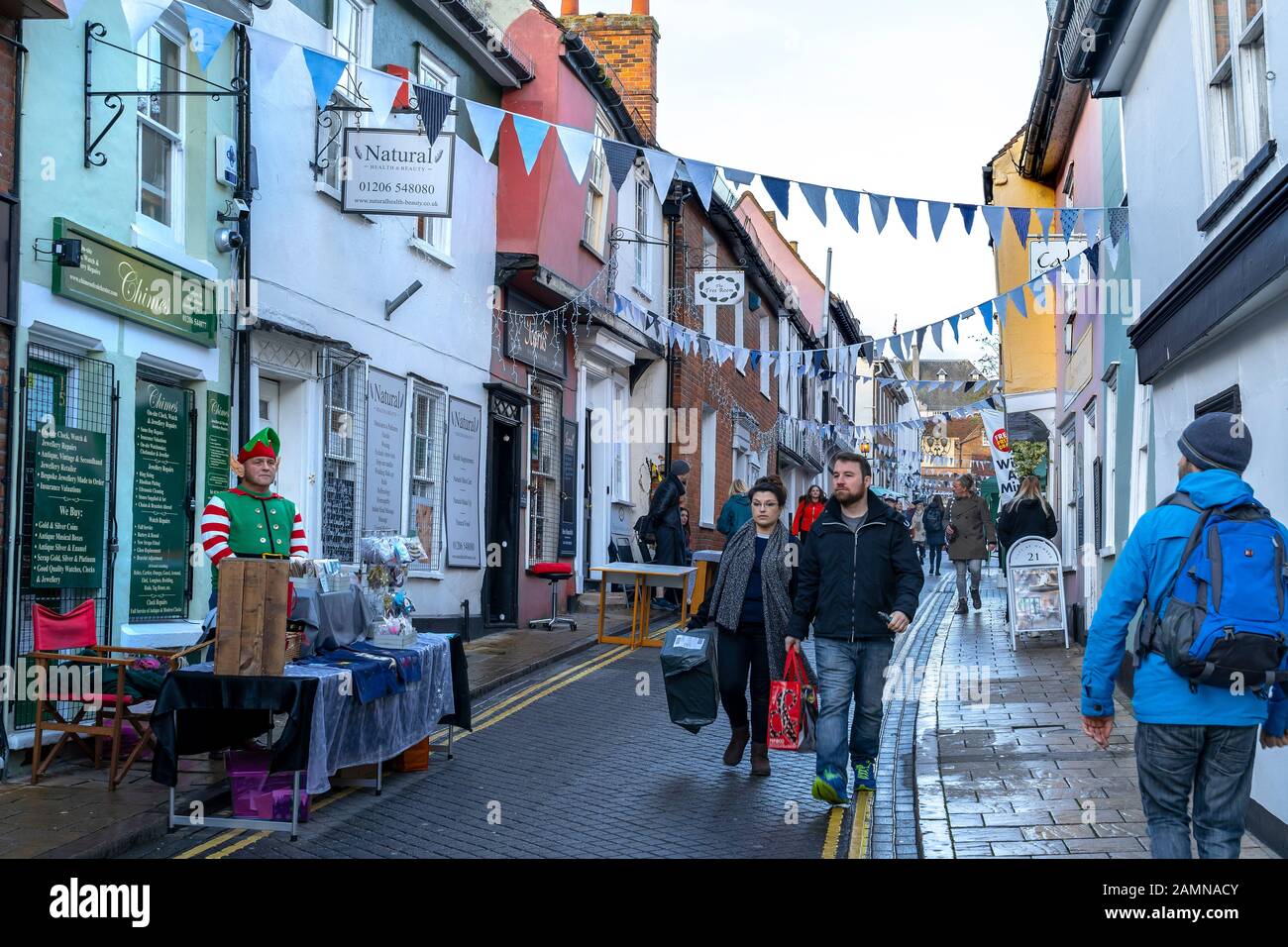 COLCHESTER, TRINITY STREET XMAS MARKET WITH SHOPPERS WALKING DOWN THE STREET Stock Photo