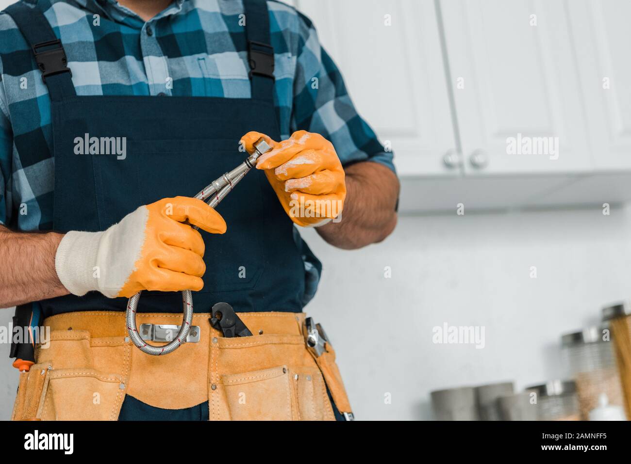 Cropped View Of Repairman In Rubber Gloves Holding Metal Hose Stock Photo Alamy
