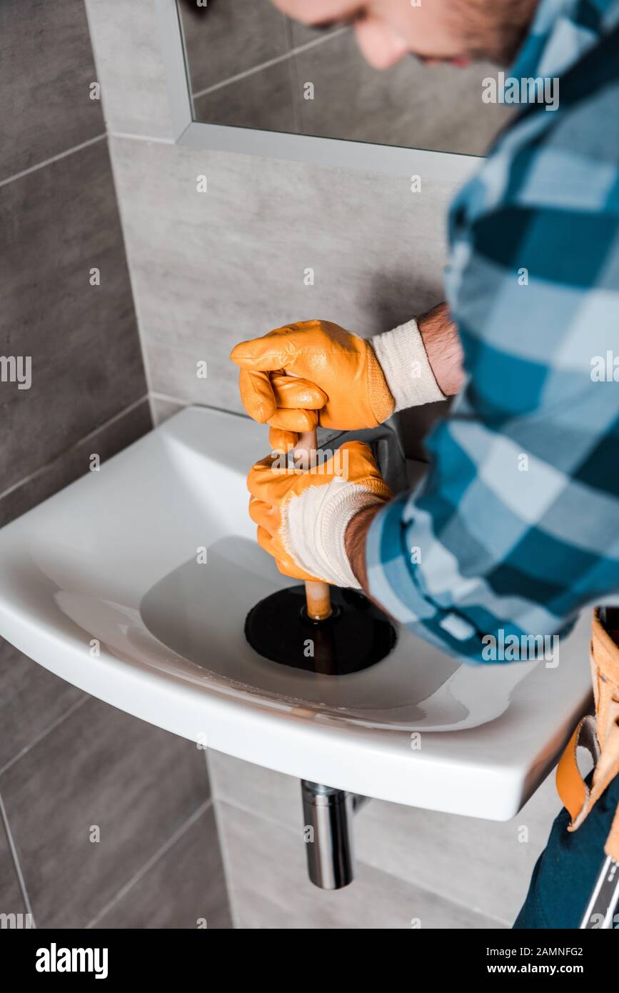 https://c8.alamy.com/comp/2AMNFG2/selective-focus-of-handyman-holding-plunger-in-sink-with-water-2AMNFG2.jpg