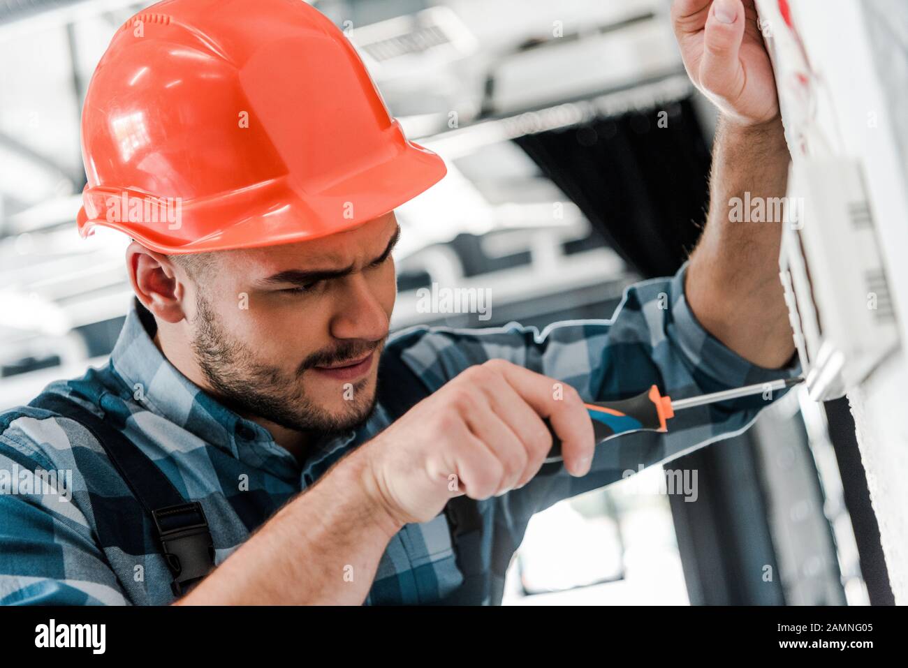 selective focus of workman repairing control panel with screwdriver ...