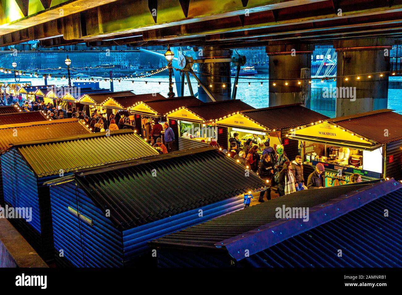 Stalls under the Hungerford Bridge at festive Southbank Centre Winter Market, London,UK, Stock Photo