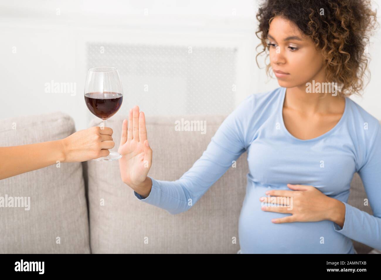 Pregnant woman gesturing stop to offered glass of wine Stock Photo Alamy