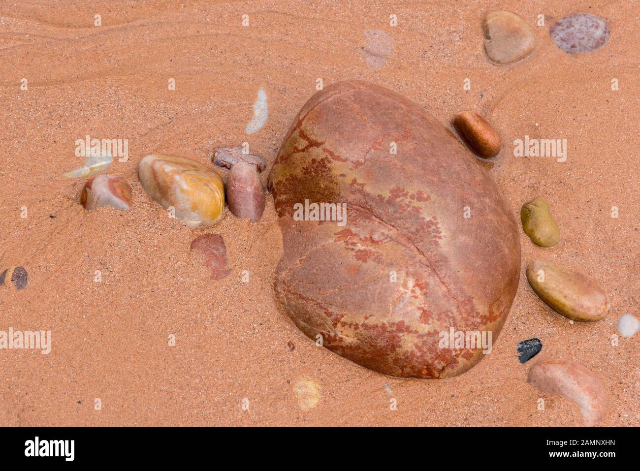 Pebbles on a small patch of sand on the beach at Budleigh Salterton, East Devon, UK Stock Photo