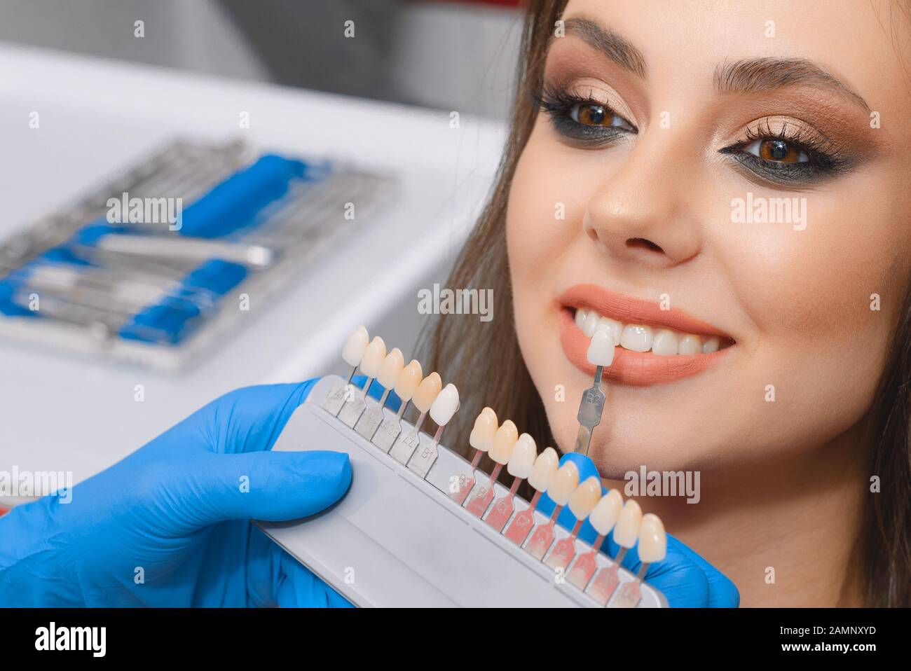 Young patient selects tooth color, crown, veneer, concept of medicine, dentistry and healthThe concept of medicine, dentistry Stock Photo