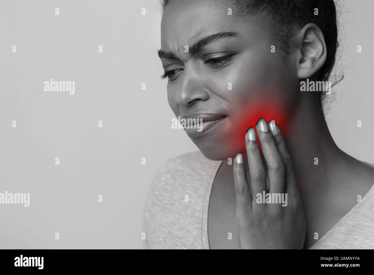 Monochrome photo of afro lady suffering from toothache Stock Photo