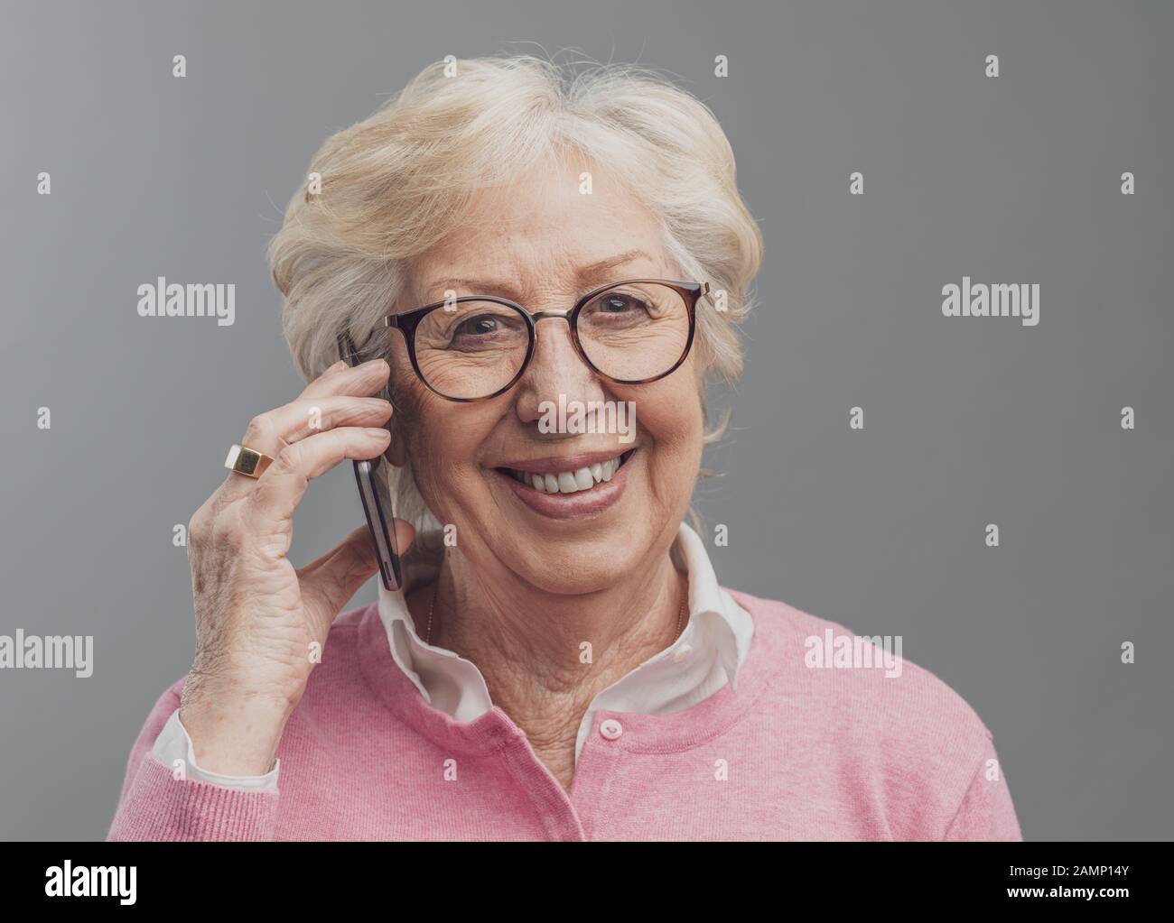 Modern happy senior lady having a phone call on her smartphone and ...