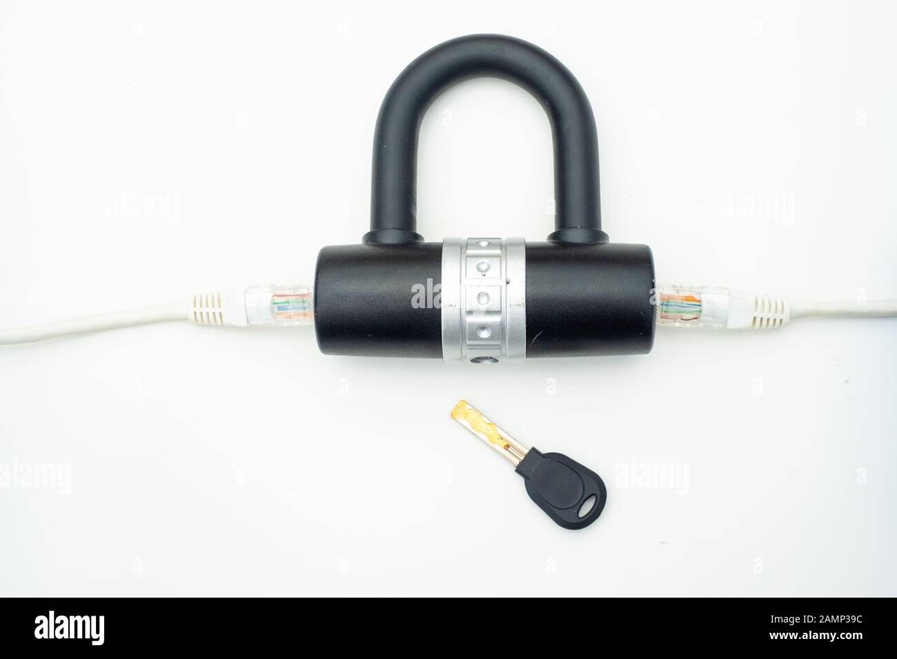 Two computer network cables going through a lock with a key, depicting digital security, cybersecurity or internet security concepts Stock Photo