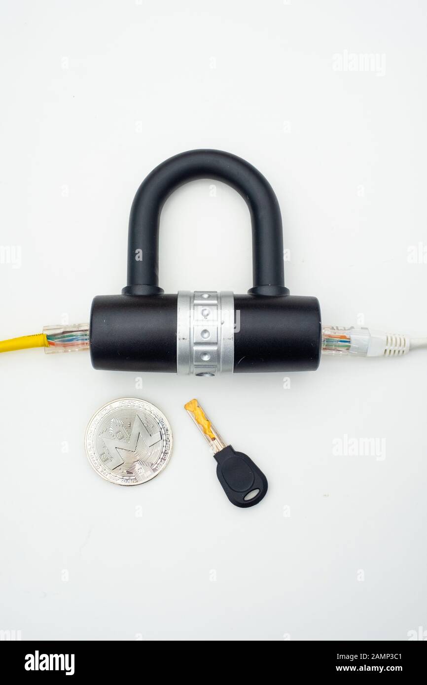 Two computer network cables going through a lock with a key and a crypto currency coin, depicting digital security, cybersecurity or internet security Stock Photo