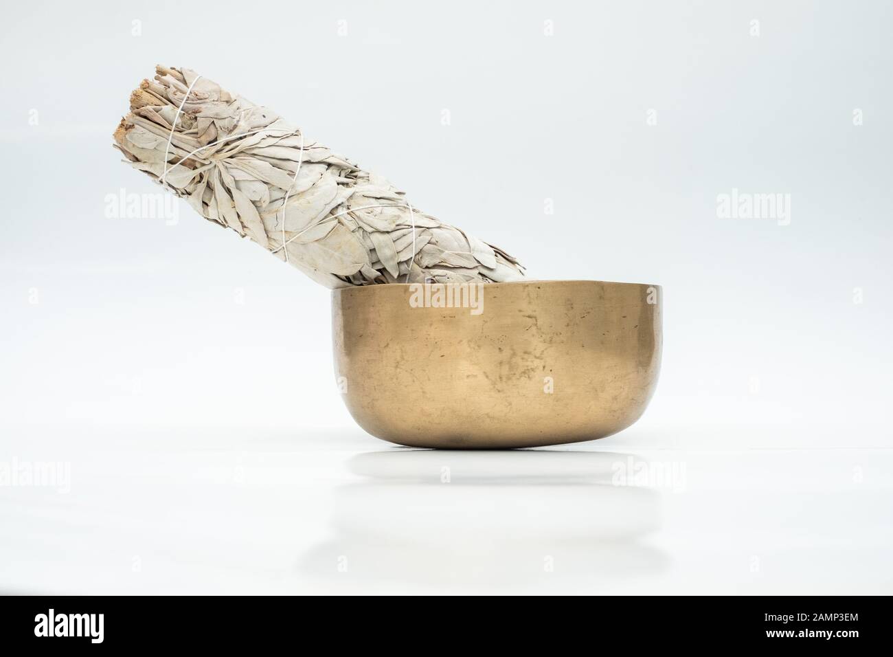 Flat lay composition of dried white sage and ancient hand crafted traditional Tibetan meditation and healing singing bowls made from 7 sacred metals which are typical accessories used in buddhism, yoga and meditation Stock Photo