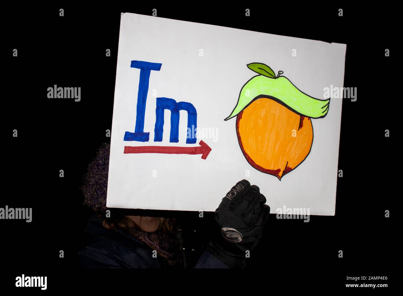 12-17-2019 Tulsa USA Woman at night political rally holds up graphic sign for impeachment Stock Photo